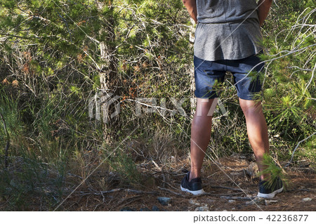 man peeing in the woods